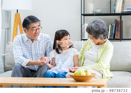リビングで団らんする孫娘と祖父母 98736722