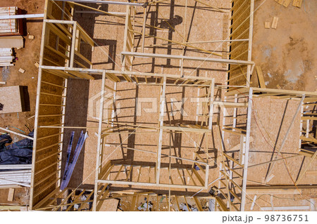 At wood framing beams that are being used in residential building construction constructed new house At wood framing beams that are being used in residential building construction constructed new house 98736751