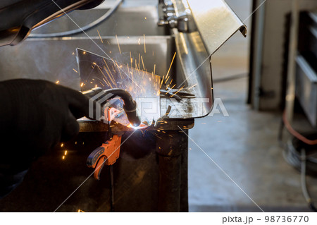Worker working welding metal with sparkle using welding machine semi automatic argon gas shielded welding Worker working welding metal with sparkle using welding machine semi automatic argon gas shielded welding 98736770