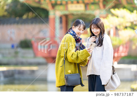 スマホで記念写真を撮る若い女性 スマホで記念写真を撮る若い女性 98737187