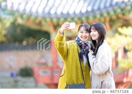 スマホで記念写真を撮る若い女性 98737188