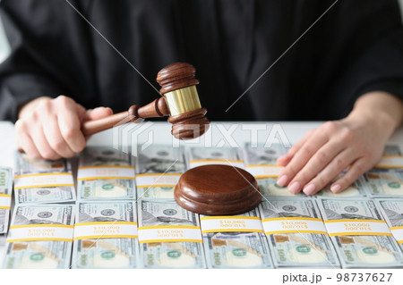 Judge with wooden gavel and a lot of dollar bills close-up. 98737627