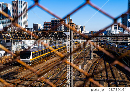 東京郊外 三鷹跨線橋の金網越しに見る電車と三鷹駅周辺 2023.01　a-2 高彩度コントラスト 98739144