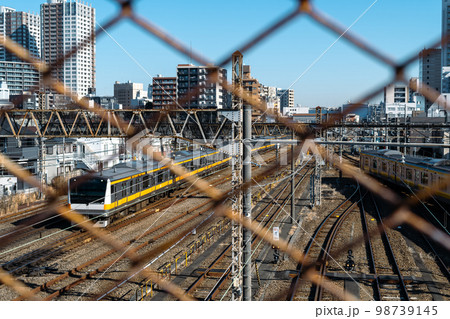 東京郊外 三鷹跨線橋の金網越しに見る電車と三鷹駅周辺 2023.01　a-3 ライトトーン 98739145