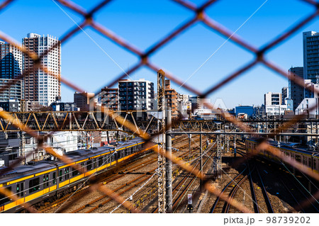 東京郊外 三鷹跨線橋の金網越しに見る電車と三鷹駅周辺 2023.01　b-2 高彩度コントラスト 98739202