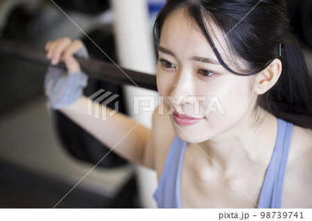 フィットネスジムでバーベルスクワットをする若い女性 フィットネスジムでバーベルスクワットをする若い女性 98739741