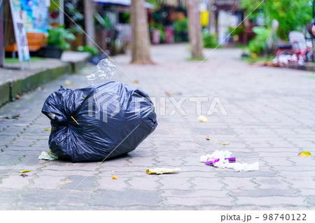 Spilled garbage on streets of big city with garbage sitting on the ground Spilled garbage on streets of big city with garbage sitting on the ground 98740122