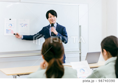 中小企業の工場・会議室・オフィスで説明・プレゼンするビジネスマン・営業・講師・セールス 98740390