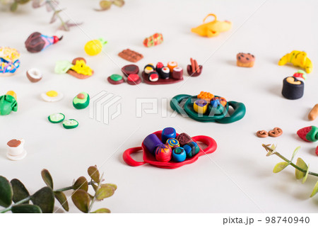Rolls on a tray and other polymer clay food on a light background. Children's leisure. 98740940