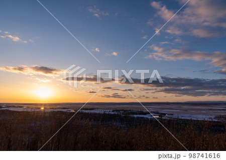 釧路湿原に沈む夕日と夕焼け色に染まる雲 98741616