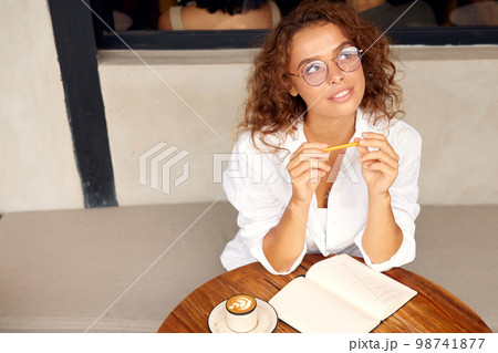 Online Work At Cafe. Thoughtful Woman Girl In Glasses Holding Pen Online Work At Cafe. Thoughtful Woman Girl In Glasses Holding Pen 98741877