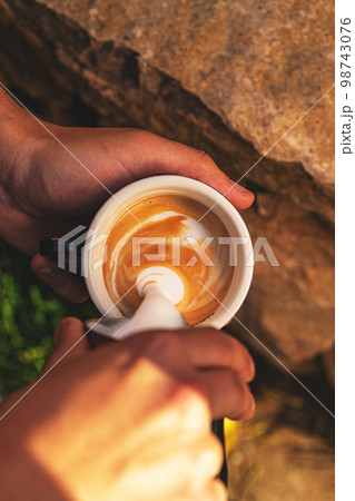 Barista pouring milk in coffee cup Barista pouring milk in coffee cup 98743076