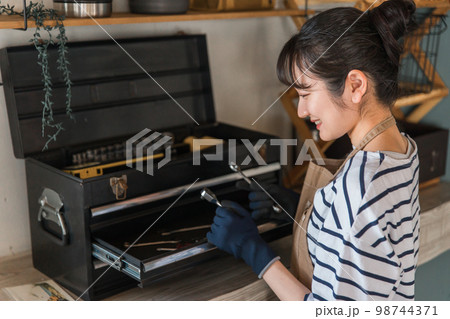 家のガレージで工具を使う女性（DIY・クラフト・日曜大工） 98744371
