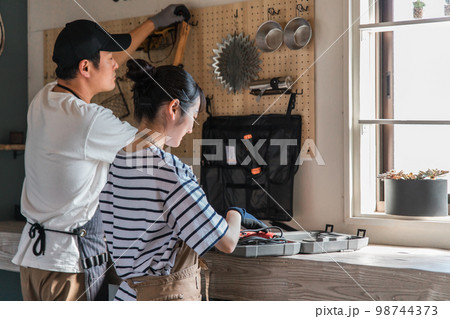 家のガレージで工具を使う男女（DIY・クラフト・日曜大工） 98744373