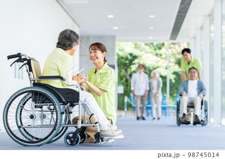 介護施設のシニアの女性と若い介護福祉士 98745014
