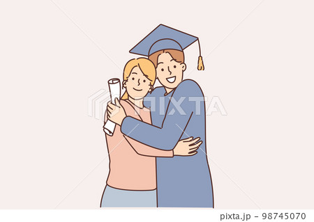 A young graduate in a cap with a diploma next to his mother A young graduate in a cap with a diploma next to his mother 98745070