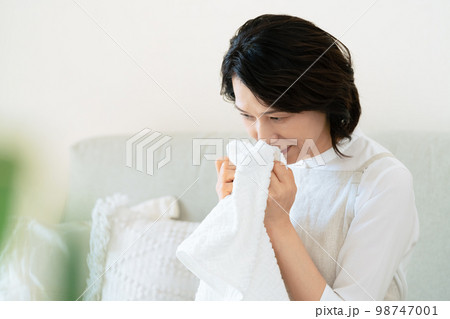 洗ったタオルの匂いを確認する女性 洗ったタオルの匂いを確認する女性 98747001