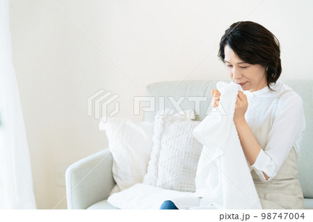 洗ったタオルの匂いを確認する女性 98747004