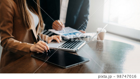 Team business meeting presentation. Hand businessman working project in modern office.Laptop computer and tablet and smart phone on white desk in morning light 98747016