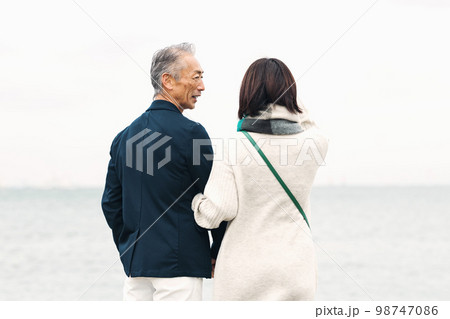 海で女性と散歩する白髪のミドル男性 98747086