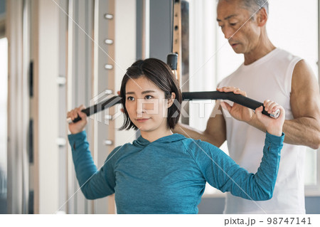 パーソナルトレーニングジムで筋トレをする若い女性 98747141