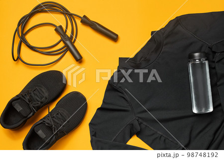 Close-up studio shot of a gym accessories on a yellow background. Top view, flat lay. Close-up studio shot of a gym accessories on a yellow background. Top view, flat lay. 98748192