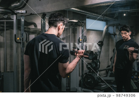ジムでダンベルを持ち上げる男性 98749306