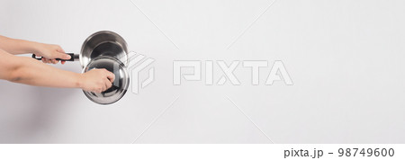 Pot cleaning Man hand on white background cleaning the non stick pot with handy dish washing sponge which yellow color on the soft side and green on hard side for hygiene after cook. Electric pot 98749600