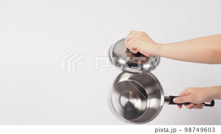 Pot cleaning Man hand on white background cleaning the non stick pot with handy dish washing sponge which yellow color on the soft side and green on hard side for hygiene after cook. Electric pot Pot cleaning Man hand on white background cleaning the non stick pot with handy dish washing sponge which yellow color on the soft side and green on hard side for hygiene after cook. Electric pot 98749603
