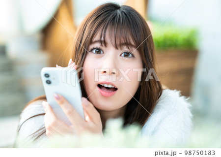 スマホで喜ぶ若い女性のアップ スマホで喜ぶ若い女性のアップ 98750183