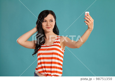 Studio photo of a gorgeous girl teenager posing over a blue background. 98751350