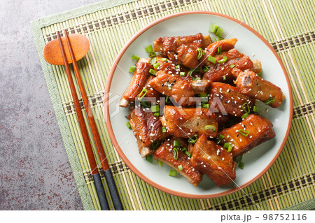 Barbecue sweet and sour spire ribs with green onion and sesame close-up in a plate. Horizontal top view Barbecue sweet and sour spire ribs with green onion and sesame close-up in a plate. Horizontal top view 98752116