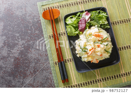 Japanese cold potato salad with carrots, cucumbers and mayonnaise close-up in a plate. horizontal top view 98752127