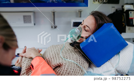 Close-up of examining patient, preparing her for transport. 98752275