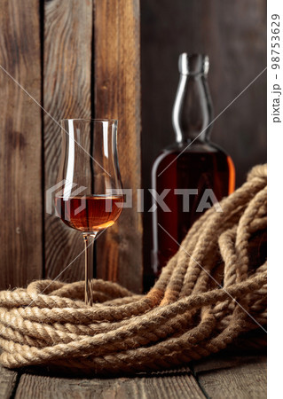Snifter and bottle with rum, cognac, or whiskey. Snifter and bottle with rum, cognac, or whiskey. 98753629