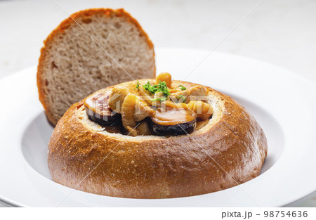 stew with pork meat, chickpeas and sausge in loaf of bread 98754636