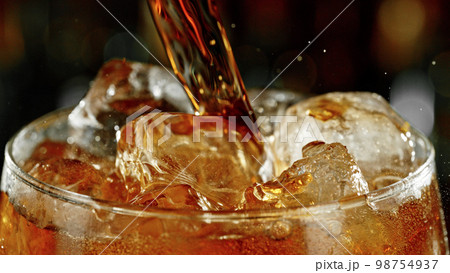 Super macro shot of pouring cola drink into glass. Super macro shot of pouring cola drink into glass. 98754937