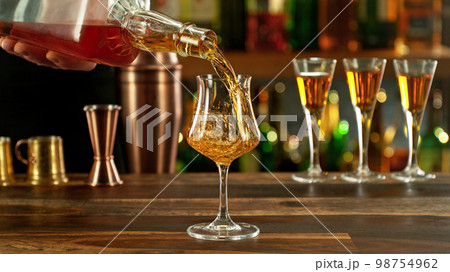 Detail of pouring rum into glass. Detail of pouring rum into glass. 98754962