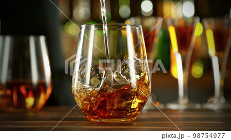 Detail of stiring whiskey glass with ice. Detail of stiring whiskey glass with ice. 98754977