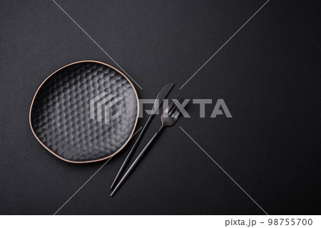 Empty ceramic round plate on dark textured concrete background 98755700
