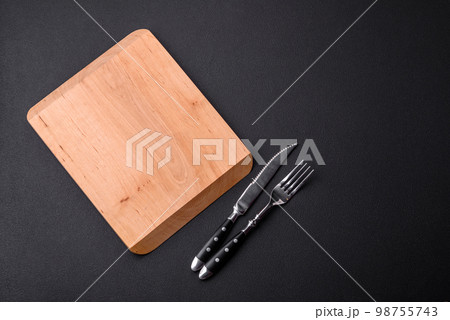 Empty wooden cutting board on dark textured concrete background 98755743