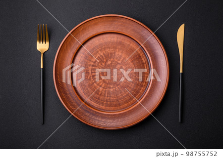 Empty ceramic round plate on dark textured concrete background 98755752