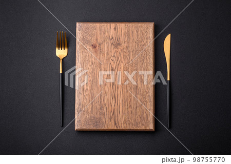 Empty wooden cutting board on dark textured concrete background 98755770