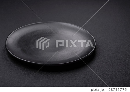 Empty ceramic round plate on dark textured concrete background 98755776