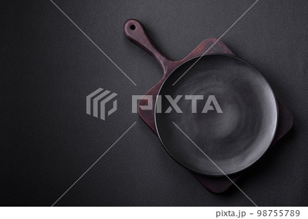 Empty ceramic round plate on dark textured concrete background 98755789