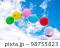 Party balloons in front of a cloudy sky. 98755823