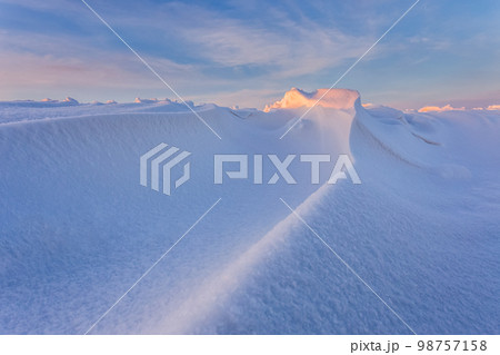 Snowdrift waves in sunset light, purple evening light at winter with a lot of snow, horizontal landscape image Snowdrift waves in sunset light, purple evening light at winter with a lot of snow, horizontal landscape image 98757158
