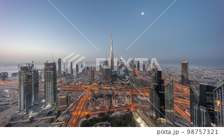 Aerial view of tallest towers in Dubai Downtown skyline and highway night to day . Aerial view of tallest towers in Dubai Downtown skyline and highway night to day . 98757321