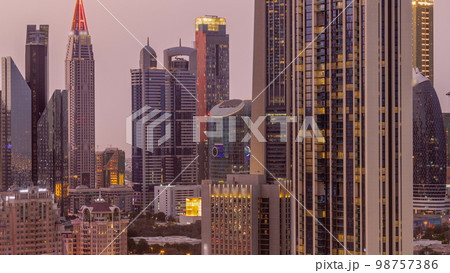 Row of the tall buildings around Sheikh Zayed Road and DIFC district aerial day to night in Dubai Row of the tall buildings around Sheikh Zayed Road and DIFC district aerial day to night in Dubai 98757386