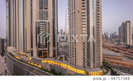 Tallest skyscrapers in downtown dubai located on bouleward street near shopping mall aerial night to day . Tallest skyscrapers in downtown dubai located on bouleward street near shopping mall aerial night to day . 98757388